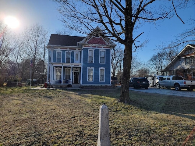 victorian house featuring a porch and a front yard