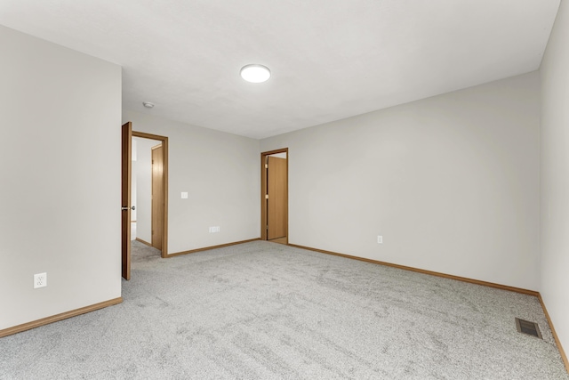 carpeted empty room featuring visible vents and baseboards