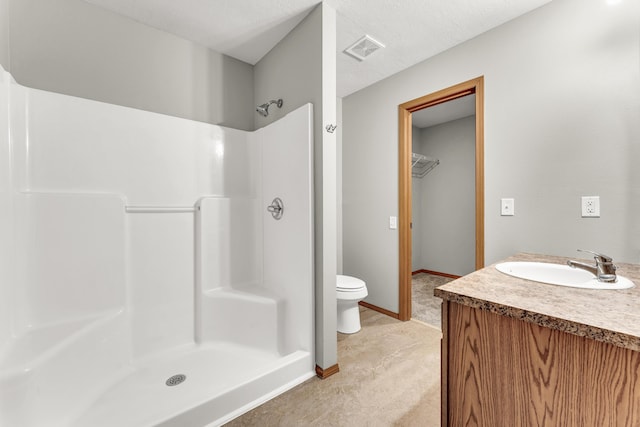 bathroom featuring visible vents, baseboards, toilet, vanity, and a shower