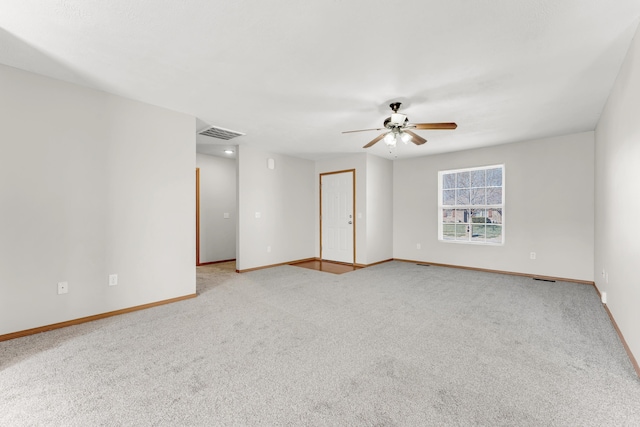 spare room with visible vents, carpet floors, baseboards, and a ceiling fan