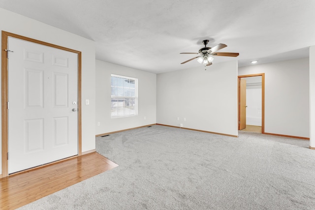 carpeted empty room featuring visible vents, baseboards, and ceiling fan