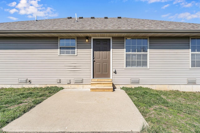 doorway to property with crawl space, a lawn, and roof with shingles