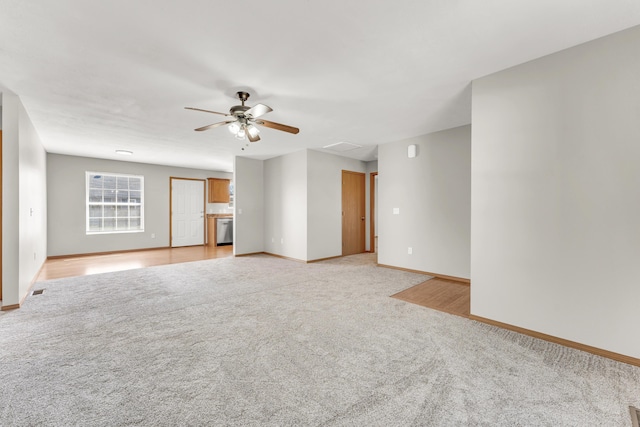 unfurnished room with baseboards, light carpet, and a ceiling fan