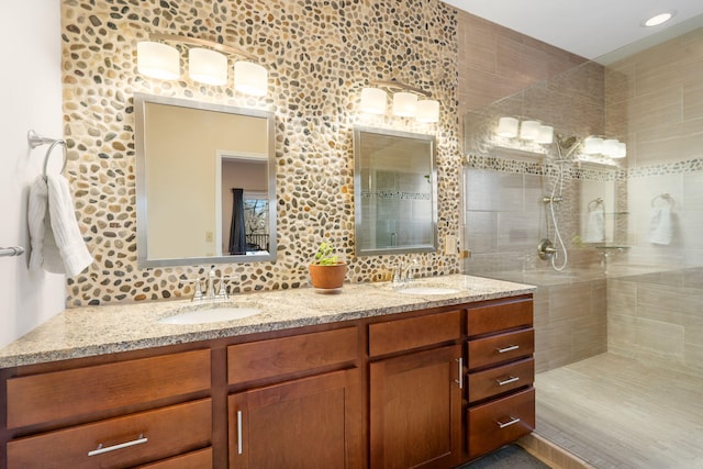 full bathroom with a sink, tasteful backsplash, walk in shower, and double vanity