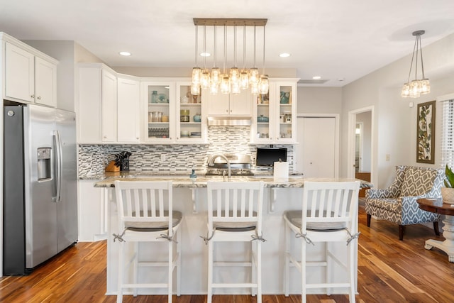 kitchen with backsplash, dark wood-style flooring, and stainless steel refrigerator with ice dispenser