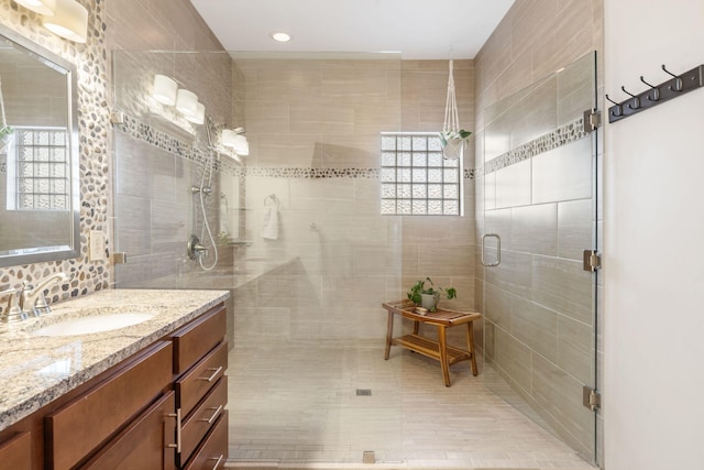 bathroom with a healthy amount of sunlight, vanity, and a shower stall