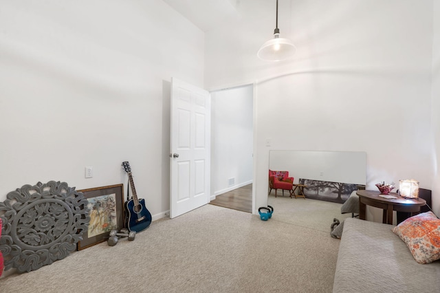 recreation room with carpet and a towering ceiling