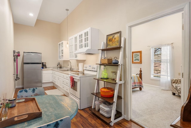 kitchen with glass insert cabinets, freestanding refrigerator, white electric stove, white cabinetry, and a sink