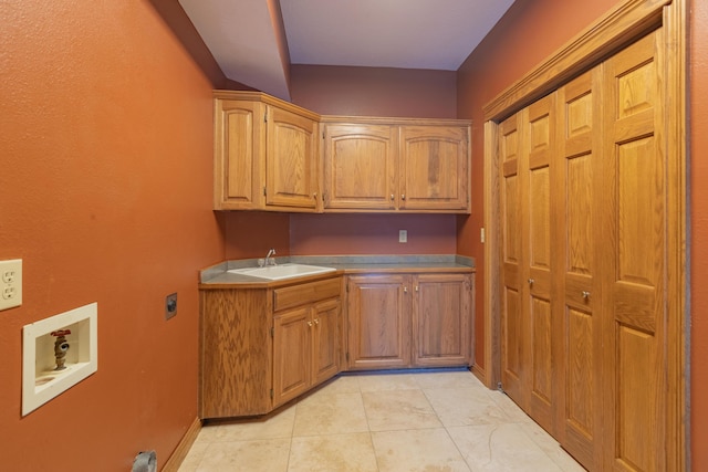 kitchen featuring a sink, baseboards, and light tile patterned floors