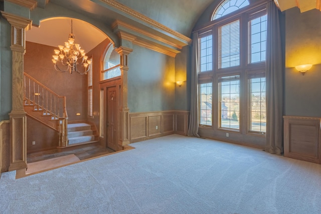 interior space with stairway, a wainscoted wall, high vaulted ceiling, and a chandelier