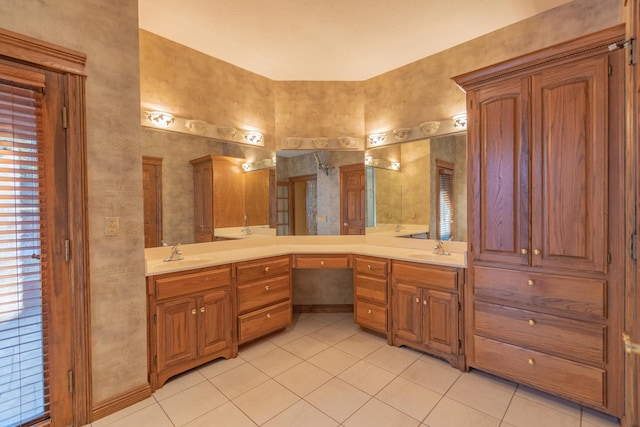 full bath with double vanity, tile patterned flooring, and a sink