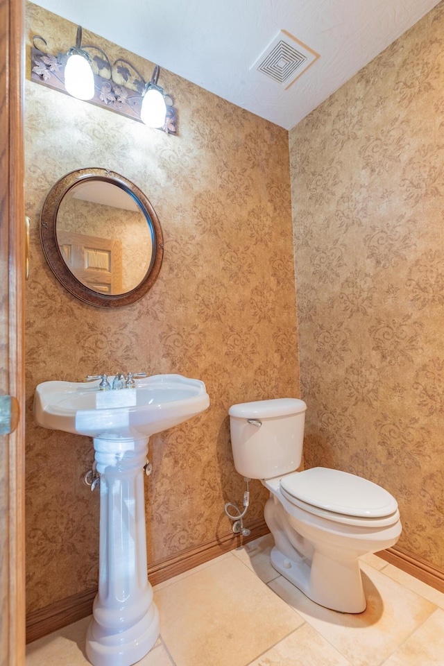 bathroom with tile patterned flooring, visible vents, wallpapered walls, and toilet