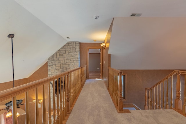 corridor featuring visible vents, lofted ceiling, and carpet