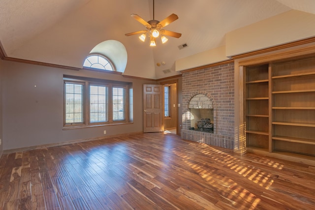 unfurnished living room with wood finished floors, visible vents, baseboards, ceiling fan, and a brick fireplace