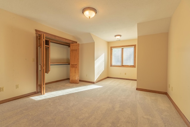 unfurnished bedroom with light colored carpet, baseboards, and a closet