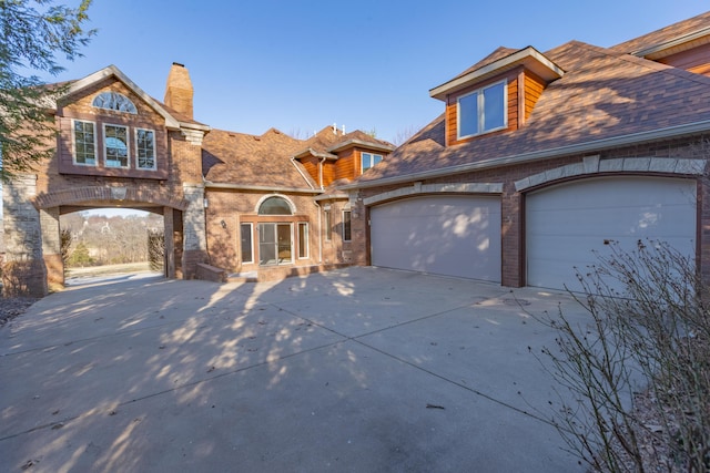 view of front of house featuring brick siding and concrete driveway