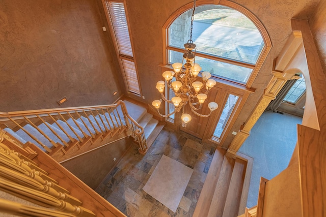 entrance foyer with a high ceiling, a chandelier, and stairs