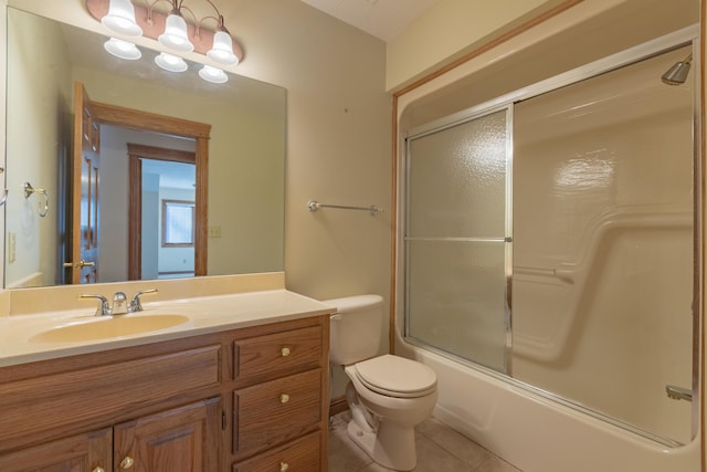 full bath featuring tile patterned floors, toilet, vanity, and shower / bath combination with glass door