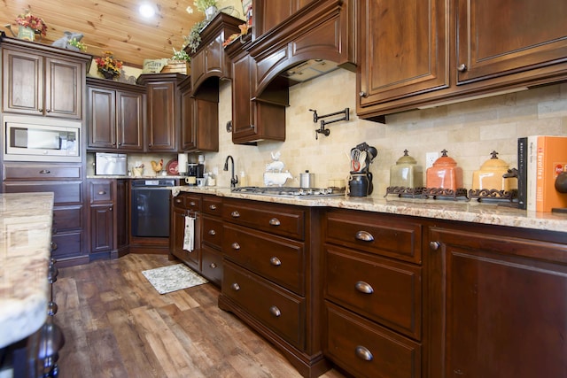 kitchen featuring dark wood-type flooring, light stone counters, backsplash, appliances with stainless steel finishes, and custom exhaust hood