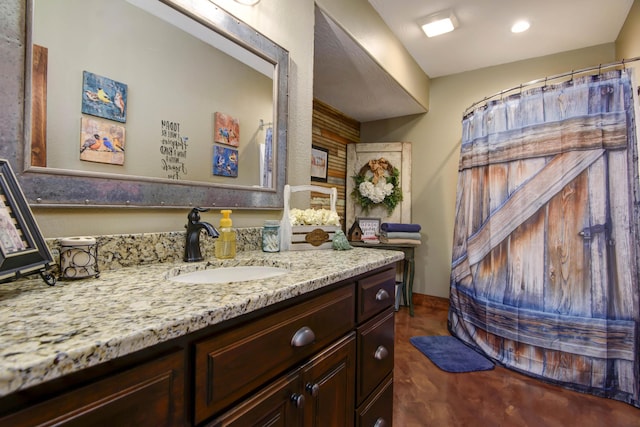 bathroom featuring baseboards, concrete flooring, and vanity