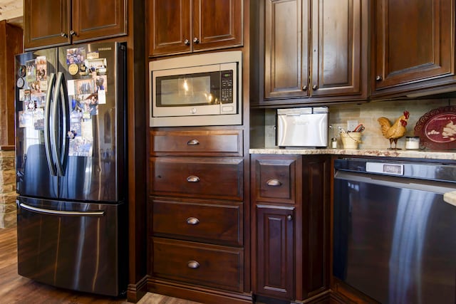 kitchen featuring light stone counters, stainless steel appliances, and tasteful backsplash