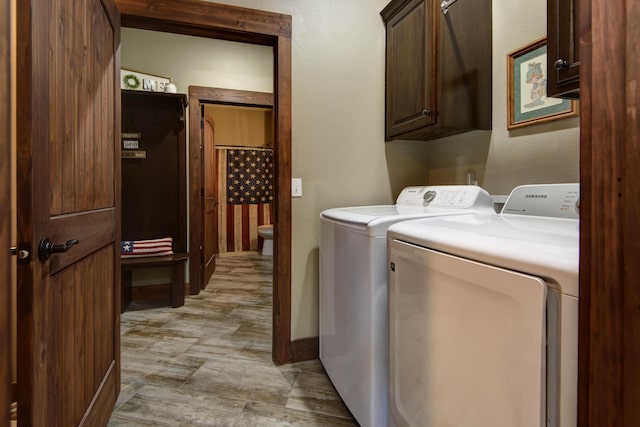 laundry room with cabinet space, baseboards, and separate washer and dryer