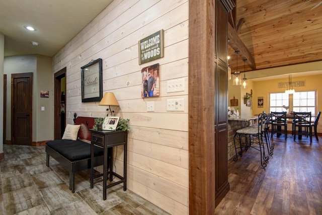 corridor featuring dark wood-style floors, wooden walls, wood ceiling, and vaulted ceiling