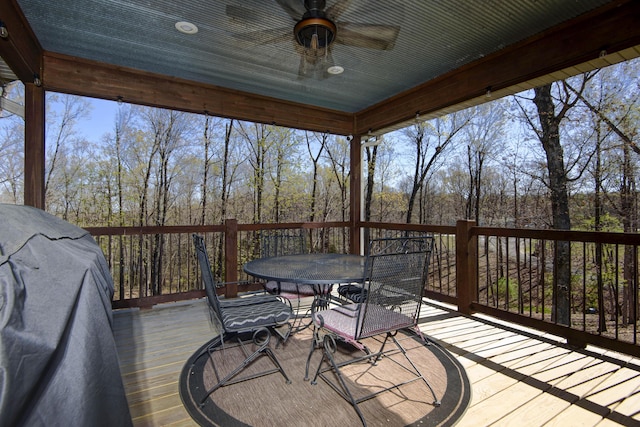 wooden terrace featuring outdoor dining area and a ceiling fan