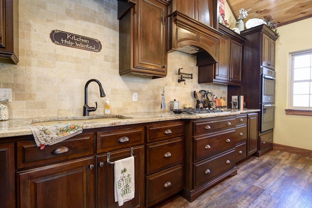 kitchen featuring dark wood-style floors, decorative backsplash, appliances with stainless steel finishes, and light stone countertops