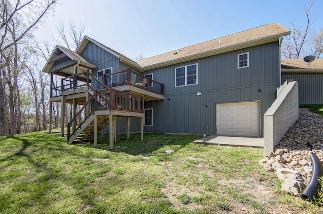 back of house featuring stairway, a lawn, a wooden deck, and an attached garage