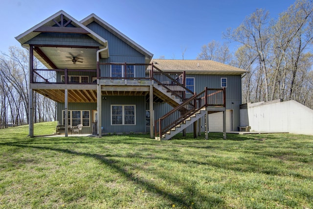 rear view of house with a patio, an attached garage, stairs, a deck, and a lawn