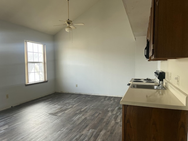 kitchen with dark wood-style flooring, electric range oven, light countertops, vaulted ceiling, and dark brown cabinetry