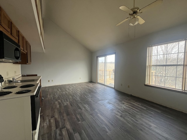 kitchen featuring range with electric cooktop, a sink, open floor plan, brown cabinetry, and black microwave