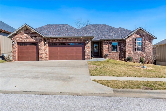 ranch-style house with brick siding, a front lawn, roof with shingles, a garage, and driveway