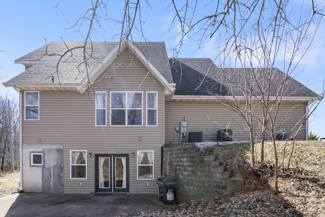 back of property featuring a patio area and roof with shingles