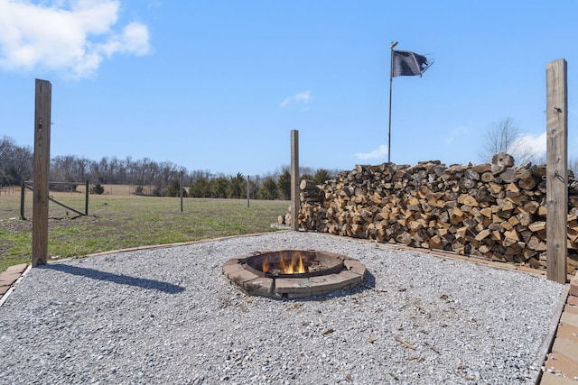 surrounding community with a fire pit and a lawn