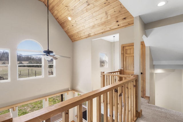 hallway featuring an upstairs landing, carpet, wooden ceiling, and high vaulted ceiling