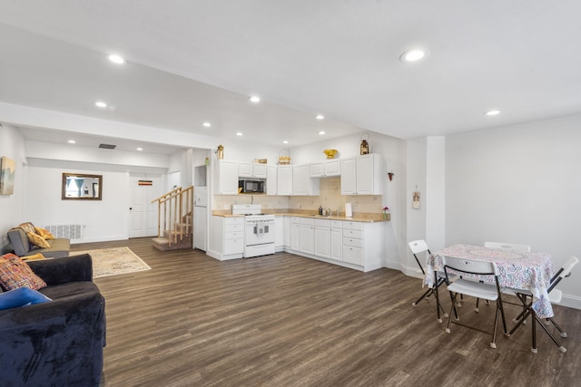 interior space featuring visible vents, gas range gas stove, dark wood-style flooring, a sink, and black microwave