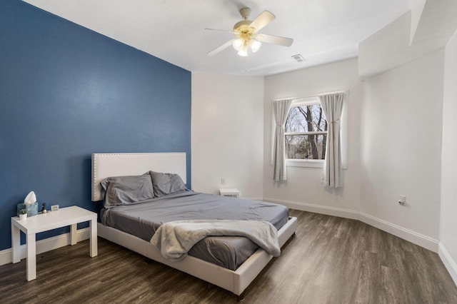 bedroom featuring visible vents, ceiling fan, baseboards, and wood finished floors