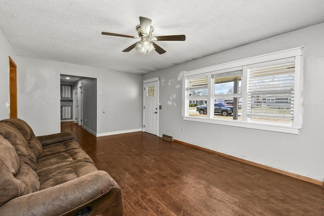 living area featuring a textured ceiling, a ceiling fan, baseboards, and hardwood / wood-style floors