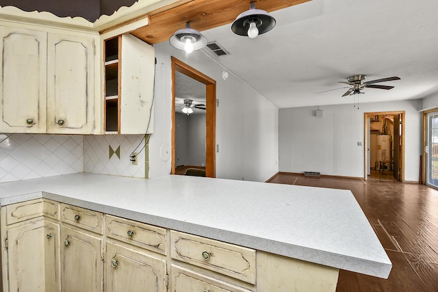 kitchen featuring visible vents, a peninsula, light countertops, and cream cabinetry