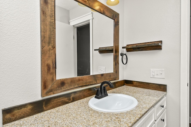 bathroom with vanity and a textured wall