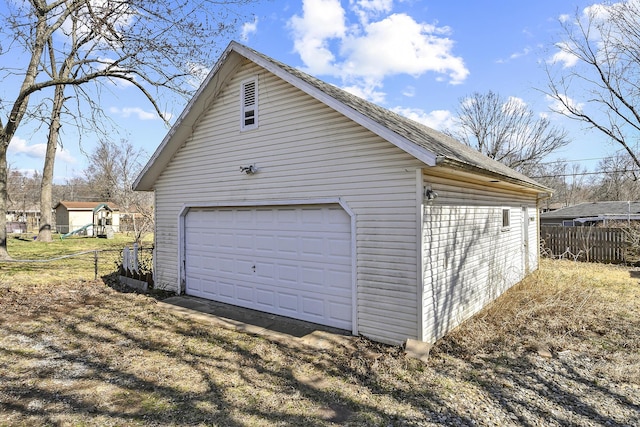 detached garage featuring fence