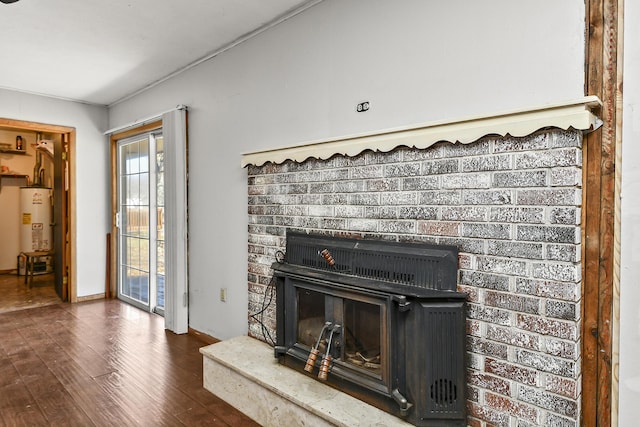 living room featuring water heater, a brick fireplace, and wood finished floors