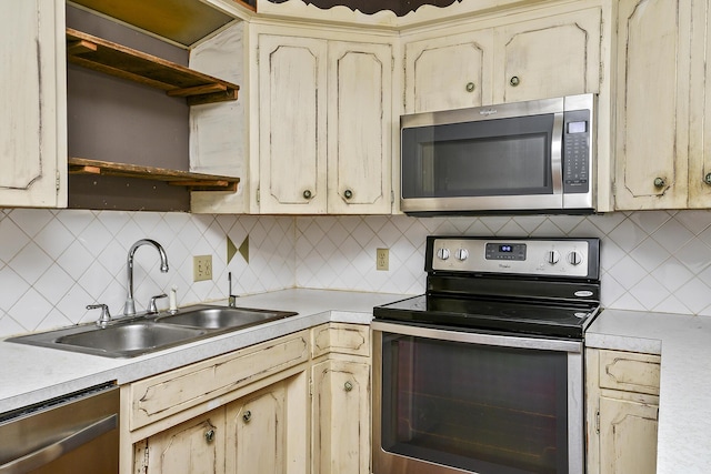 kitchen featuring a sink, open shelves, light countertops, and stainless steel appliances