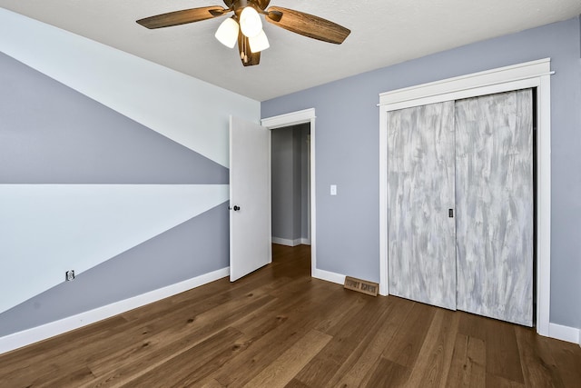 unfurnished bedroom with visible vents, a ceiling fan, baseboards, and hardwood / wood-style floors