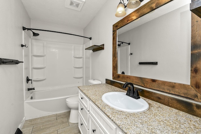 bathroom with vanity, visible vents, wood tiled floor, shower / bath combination, and toilet