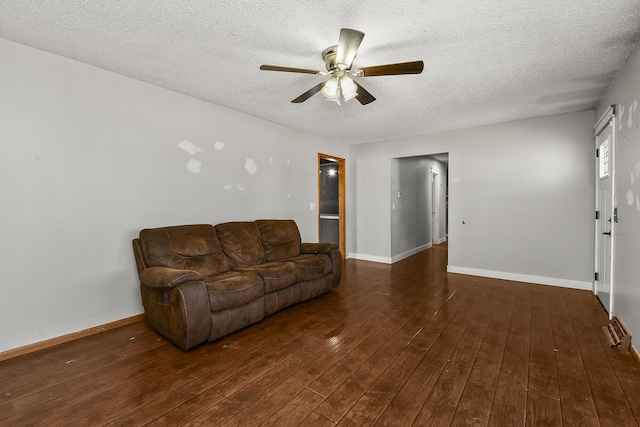 living area with baseboards, a textured ceiling, and hardwood / wood-style floors