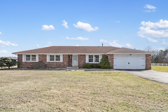 ranch-style house featuring brick siding, a front lawn, an attached garage, and driveway