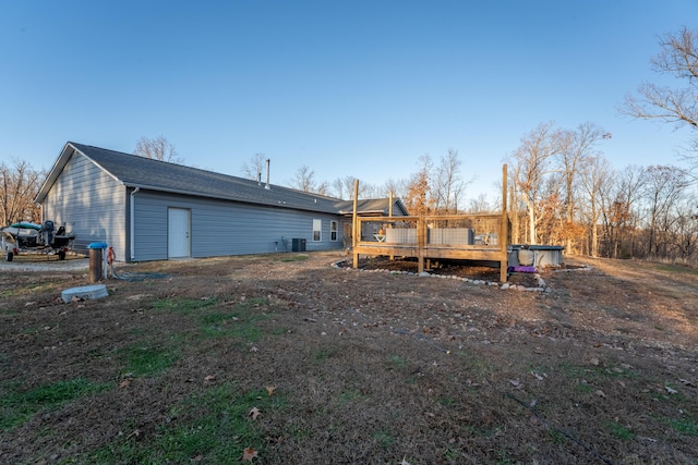 back of house featuring central air condition unit and a wooden deck